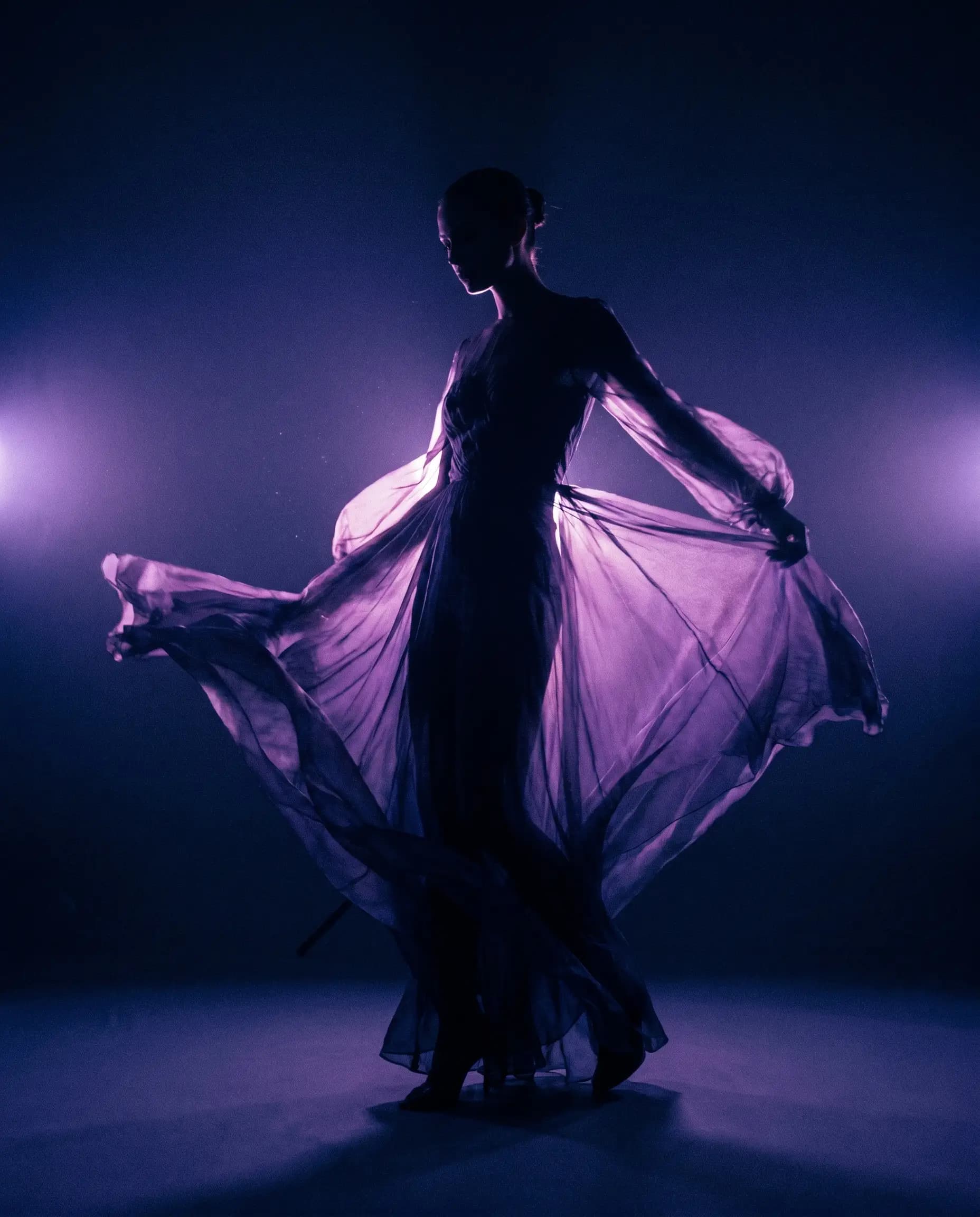 A silhouette in flowing fabric mid-motion under violet and magenta light — spec ad concept.